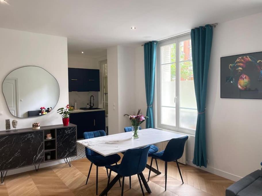 - un salon avec une table, des chaises et un miroir dans l'établissement New appartement charmant et lumineux, à Paris