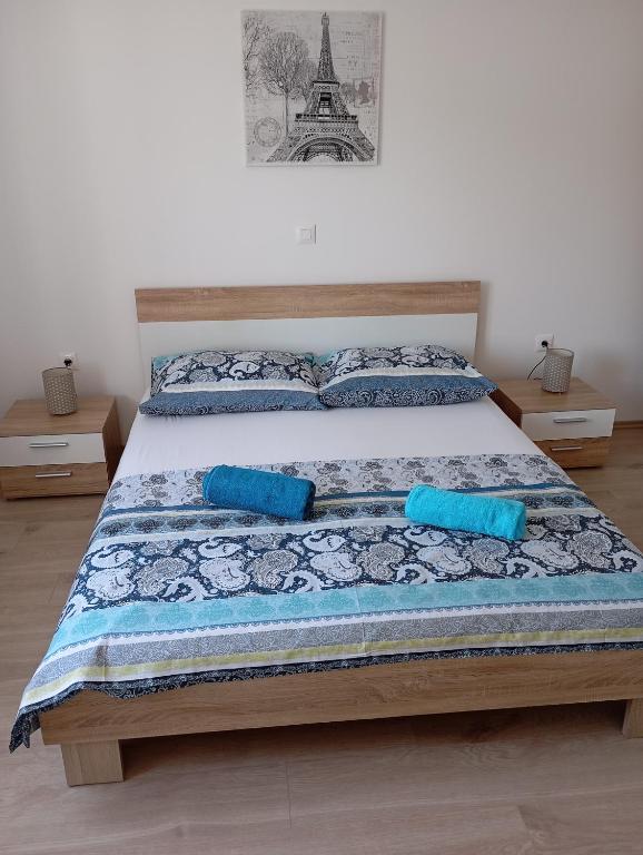 ein Bett mit zwei blauen Kissen und dem Eiffelturm in der Unterkunft House Daniela in Omišalj