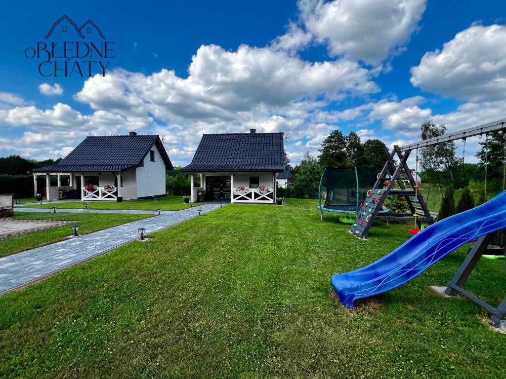 a playground with a slide and a house at oBłędne Chaty in Radków
