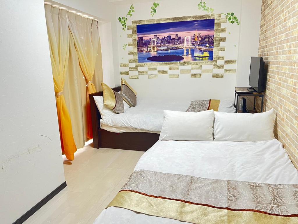 a room with two beds and a television in it at 403 Oshiage sta 3mins walk! Wi-Fi & Elevator 4pax in Tokyo