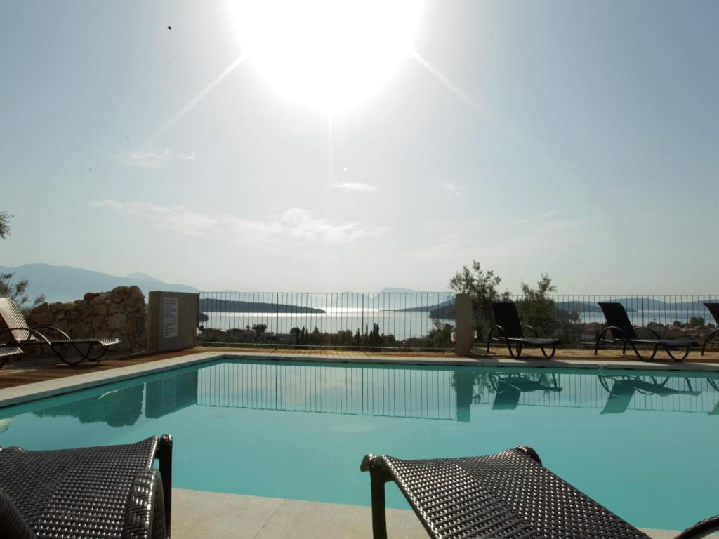 a swimming pool with two chairs in a resort at Princes ' Islands Luxury Residences in Nydri