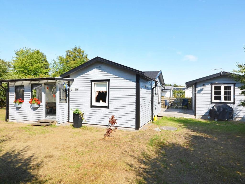 a small white house with a window and a yard at 10 person holiday home in Skummeslövsstrand in Skummeslövsstrand