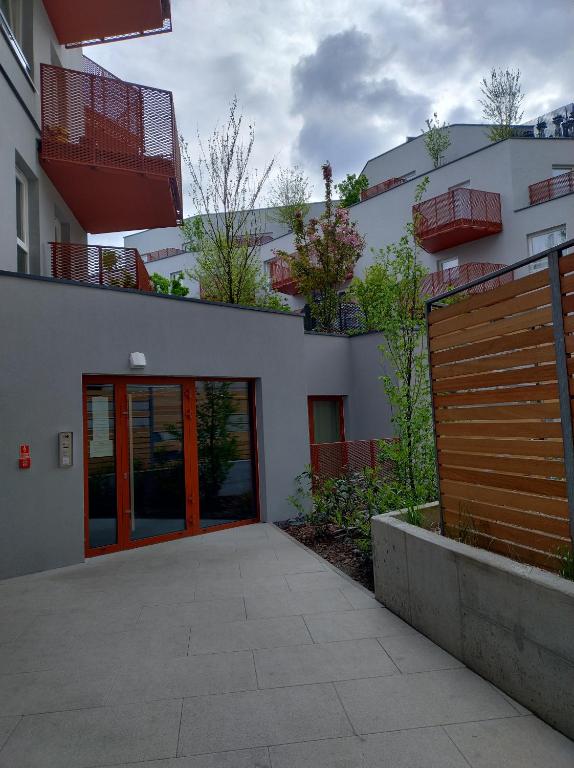 un edificio con una puerta roja y una valla en Apartament Mona Jeżyce, en Poznan