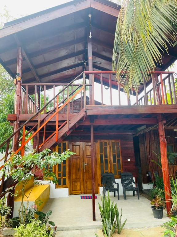 a house with a wooden staircase in the middle at Another World in Arugam Bay