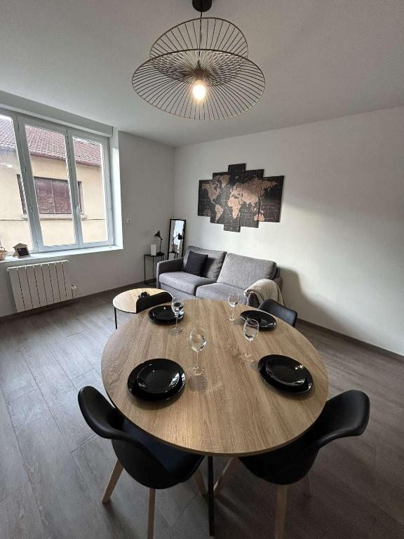 un salon avec une table avec des chaises et un canapé dans l'établissement Le Grand RepublicainT2, au Péage-de-Roussillon