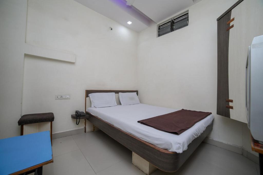 a small bedroom with a bed in a room at SPOT ON Shraddha Hotel in Nagpur