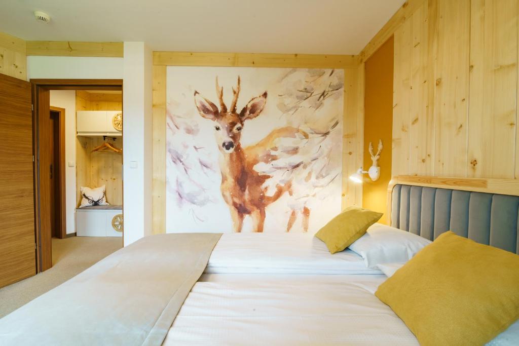 a large bed with a painting of a deer on the wall at DW Boguń Pokoje i Apartamenty in Białka Tatrzańska