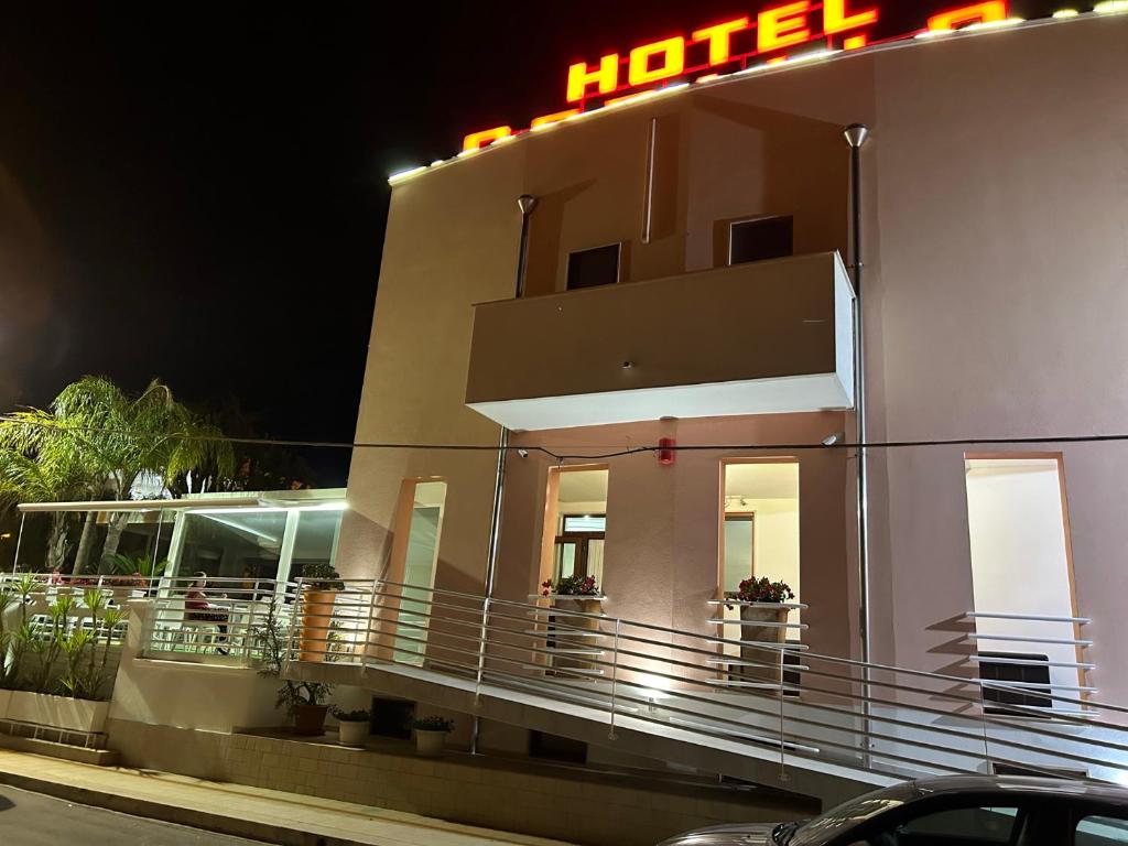 a hotel with a neon sign on the side of it at Hotel Corallo in Torre Santa Sabina