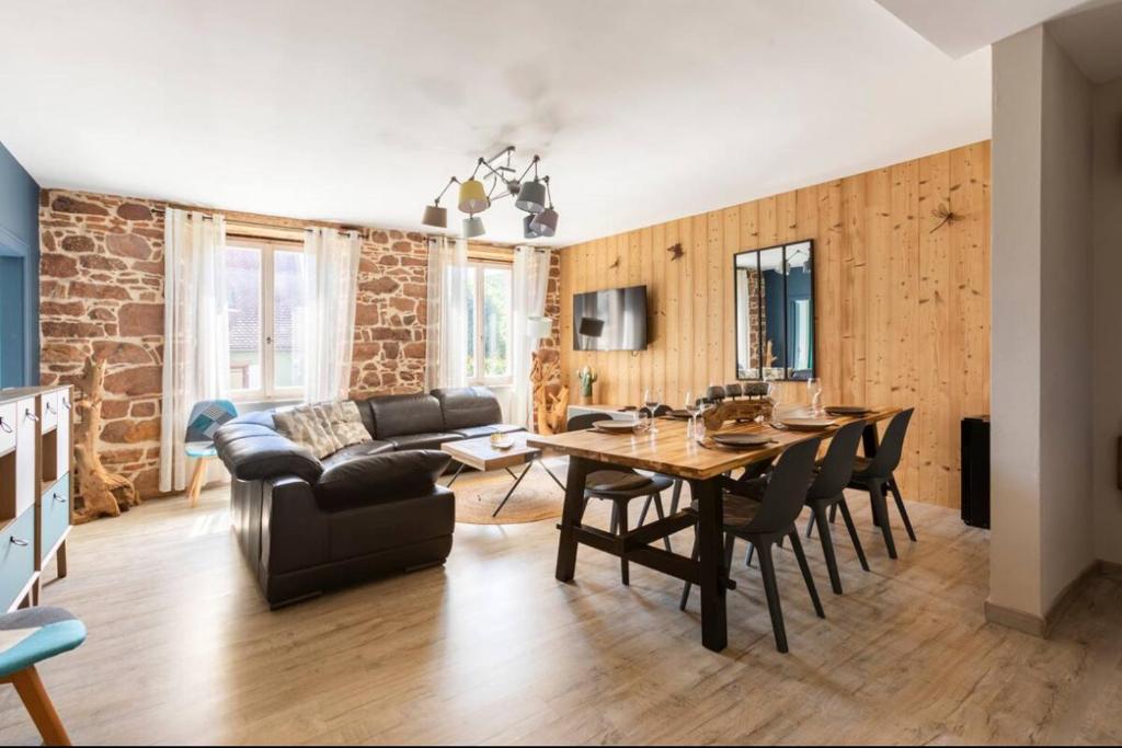 a living room with a table and a couch at Les Boisés à Kaysersberg+ 1 place de parking in Kaysersberg