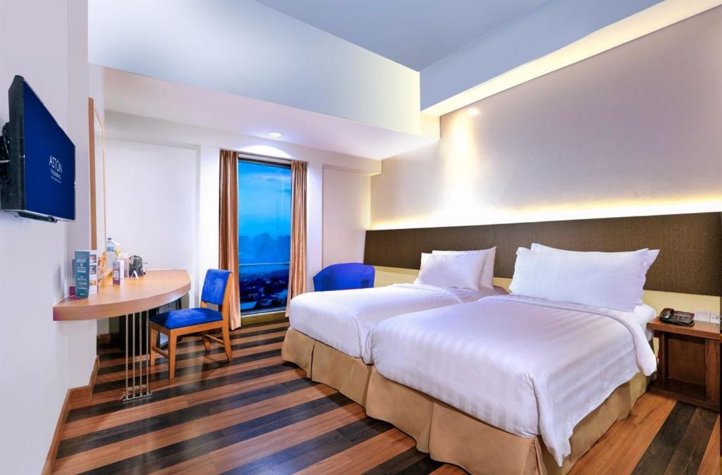Postel nebo postele na pokoji v ubytování Aston Palembang Hotel & Conference Centre