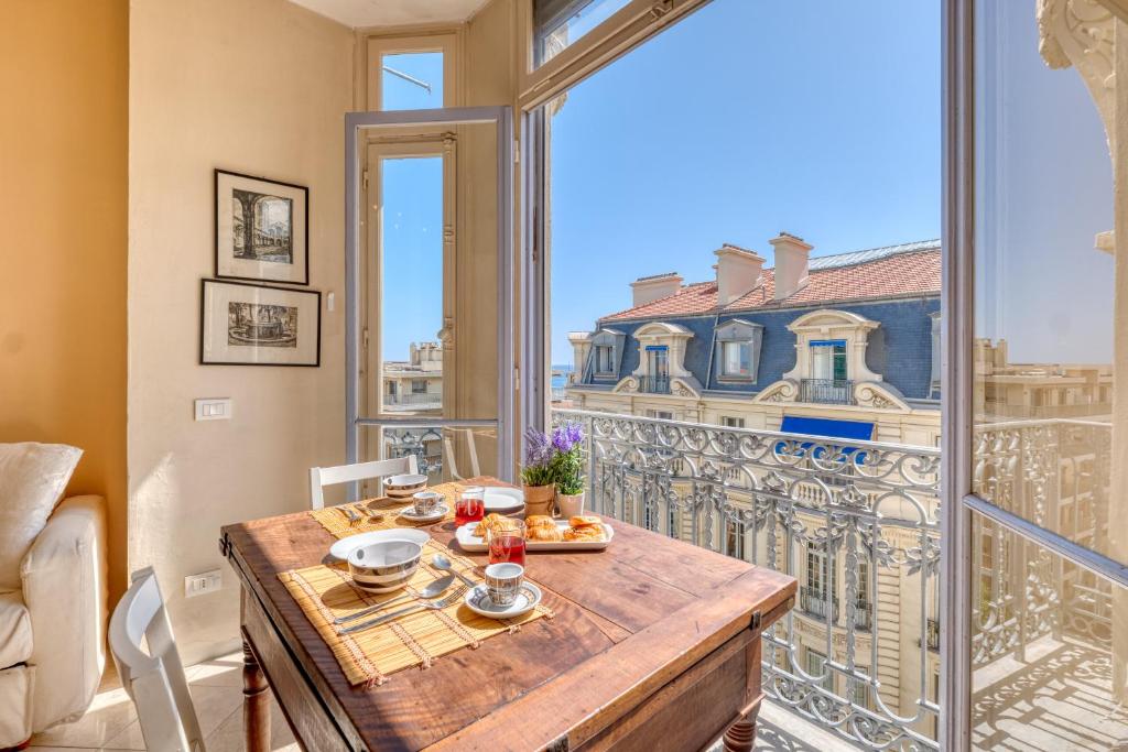 une salle à manger avec une table et une vue sur la ville dans l'établissement Astoria Bow Window Studio - Happy Rentals, à Menton