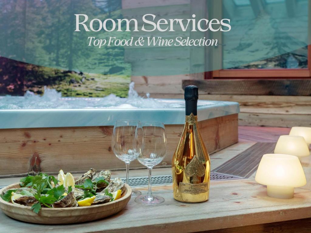 a bottle of wine and two wine glasses on a table at Francois Boutique Rooms - Matterhorn Retreat & SPA in Cervinia in Breuil-Cervinia