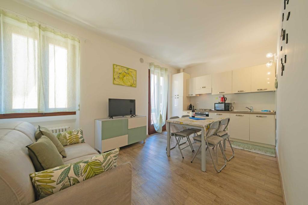 Una cocina y una sala de estar con un sofá y una mesa. en ApartmentsGarda - Residenza Emanuele, en Torri del Benaco
