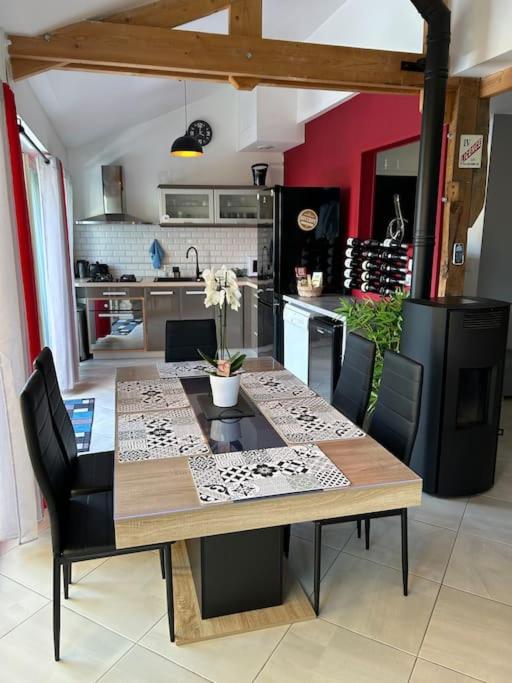 une table de salle à manger avec des chaises et une cuisine dans l'établissement Made in Beaufort, à Beaufort-en-Vallée