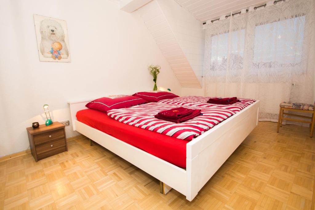 a bedroom with a large bed with red pillows at Ferienwohnung Emilia in Speyer