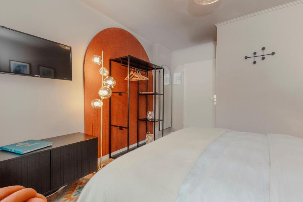 a bedroom with a large bed and a tv at Hotel Lux in Munich