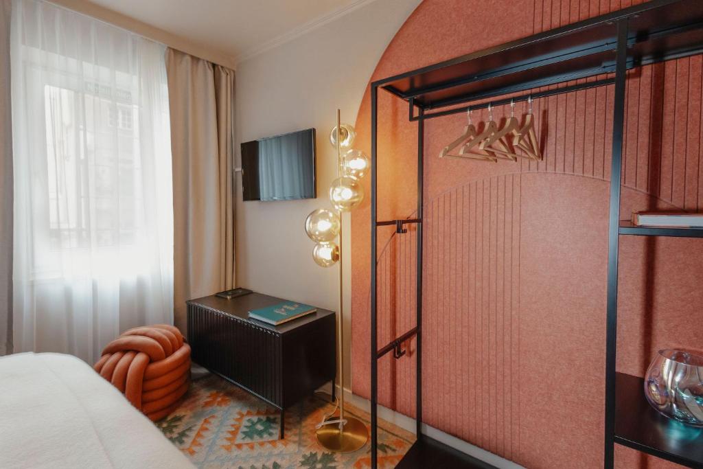 a bedroom with a bed and a dresser in a room at Hotel Lux in Munich