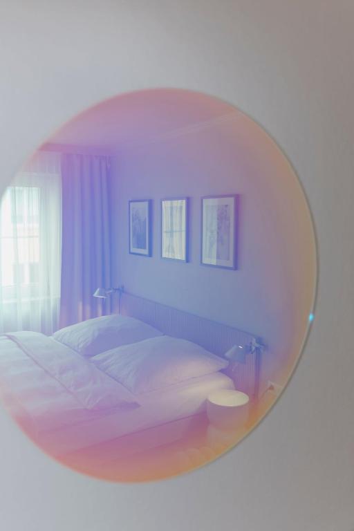 a bedroom with a large circular mirror over a bed at Hotel Lux in Munich