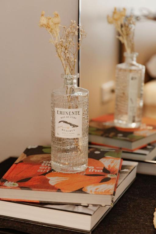 a bottle with flowers in it sitting on top of a table at Hotel Lux in Munich