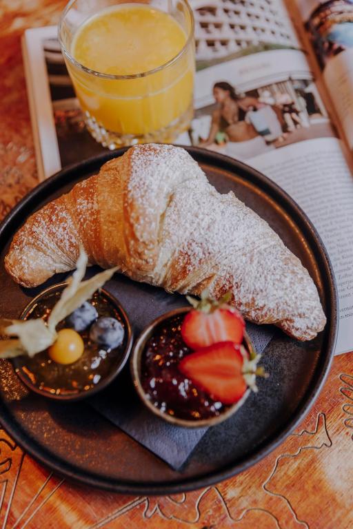a plate of food with bread and fruit on a table at Hotel Lux in Munich