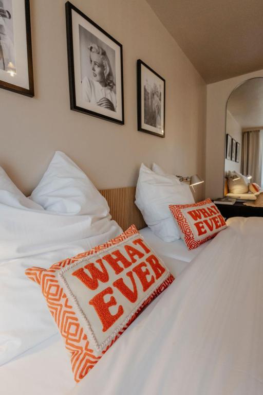 two beds in a hotel room with red and white pillows at Hotel Lux in Munich