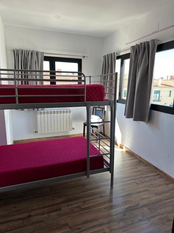 Un dormitorio con dos literas en una habitación. en Apartamentos EL SOHO INDUSTRIAL, en Ávila