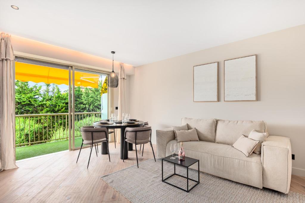 un salon avec un canapé et une table dans l'établissement L'OREE DU CAP-Somptueux 2 pièces- Garage- Terrasse, à Roquebrune-Cap-Martin