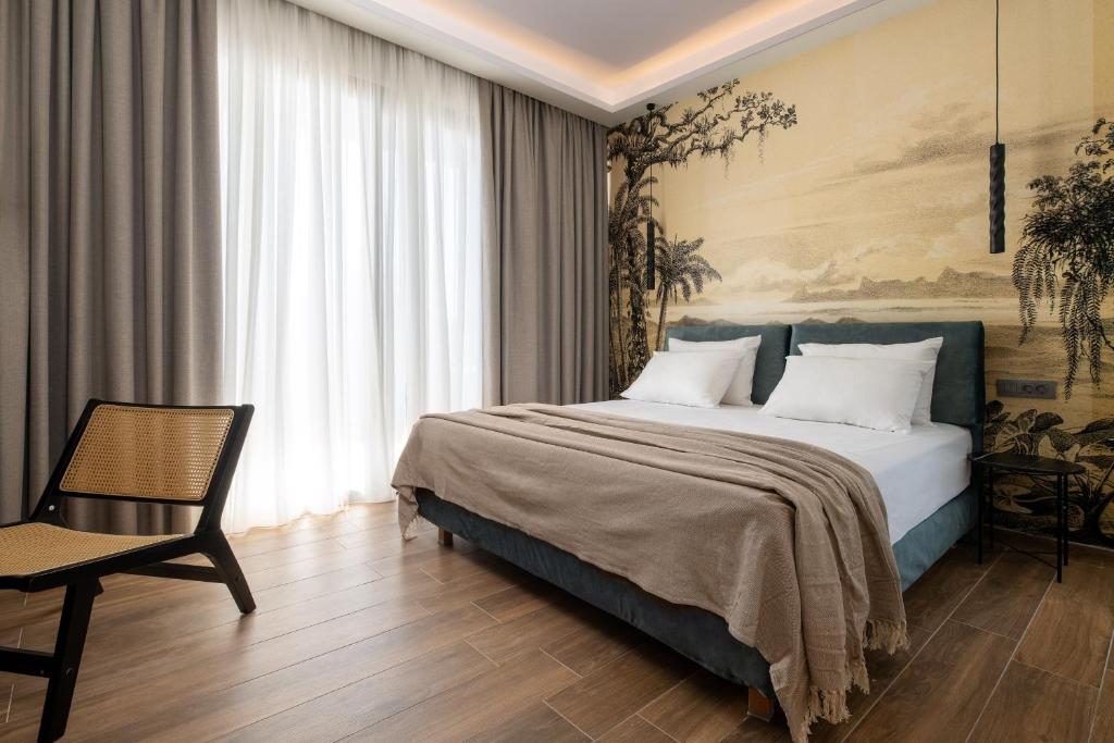 une chambre avec un grand lit et une chaise dans l'établissement La Siesta Villas, à Ixia