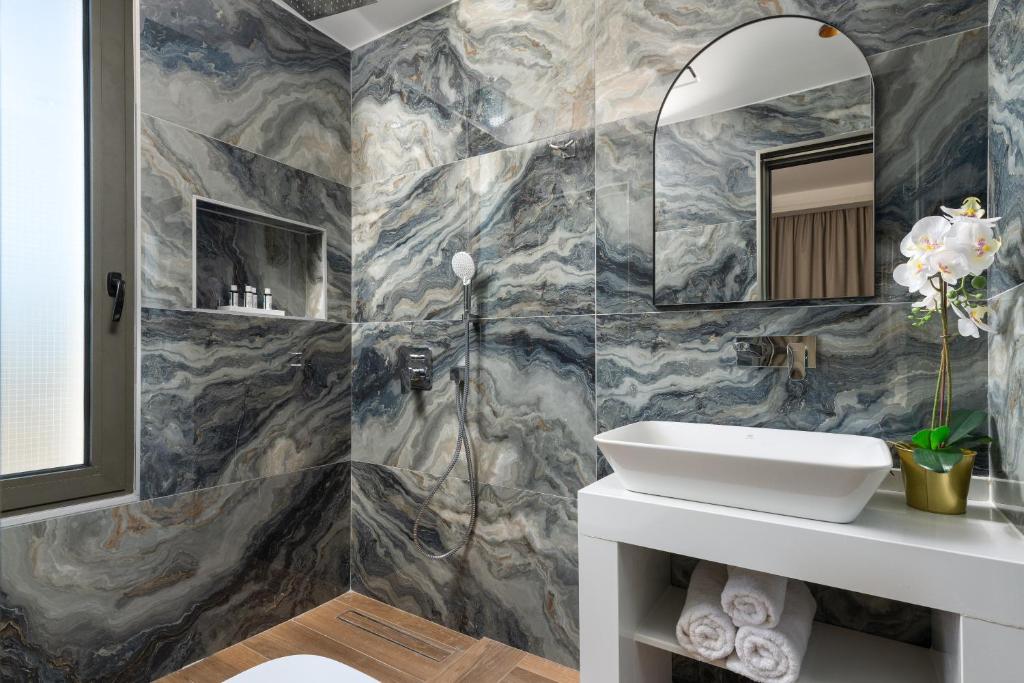 une salle de bain avec un lavabo et un miroir dans l'établissement La Siesta Villas, à Ixia
