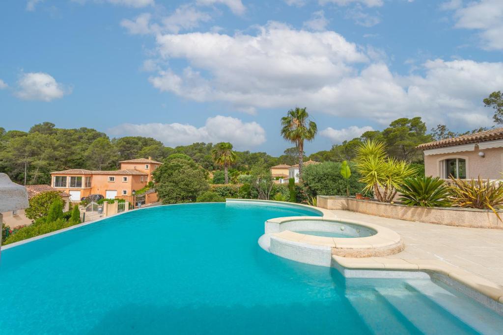 une grande piscine bleue dans une cour dans l'établissement Villa Bonheur, à Saint-Raphaël