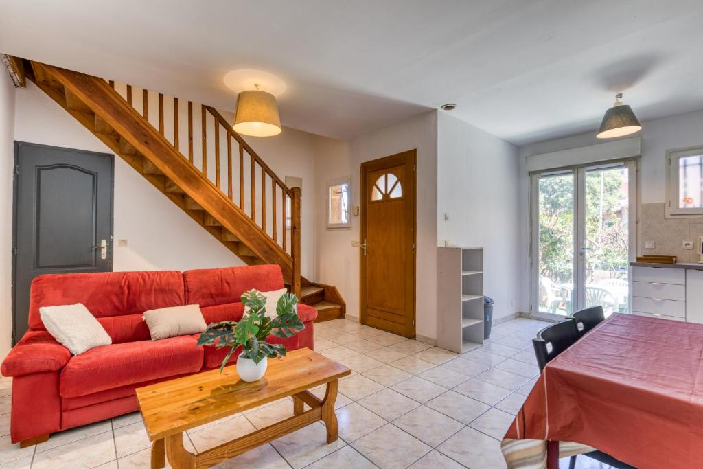 un salon avec un canapé rouge et une table dans l'établissement Villa 4-6p Montpellier - Ovalie, à Montpellier