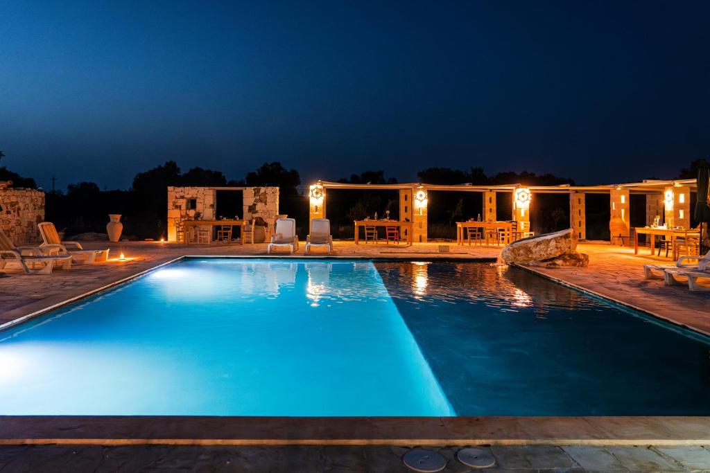 a large swimming pool at night with a resort at Masseria della Piana in Villanova di Ostuni
