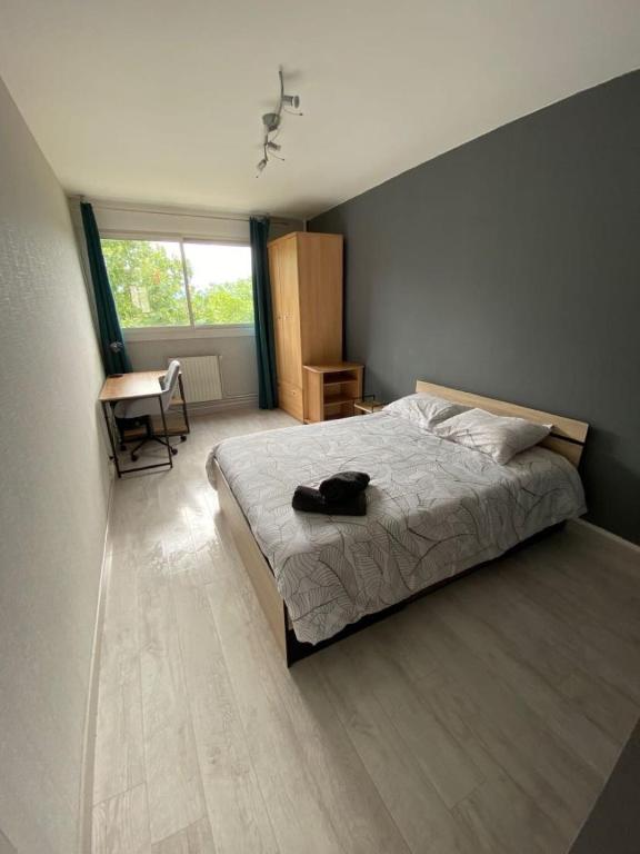 une chambre avec un lit, une chaise et une fenêtre dans l'établissement Appartement T4 95m2 avec Petit Déjeuner, à Vénissieux