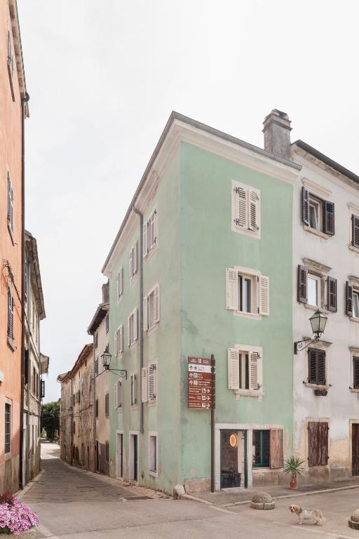a green and white building on the side of a street at Piccolo Hotel in Vodnjan
