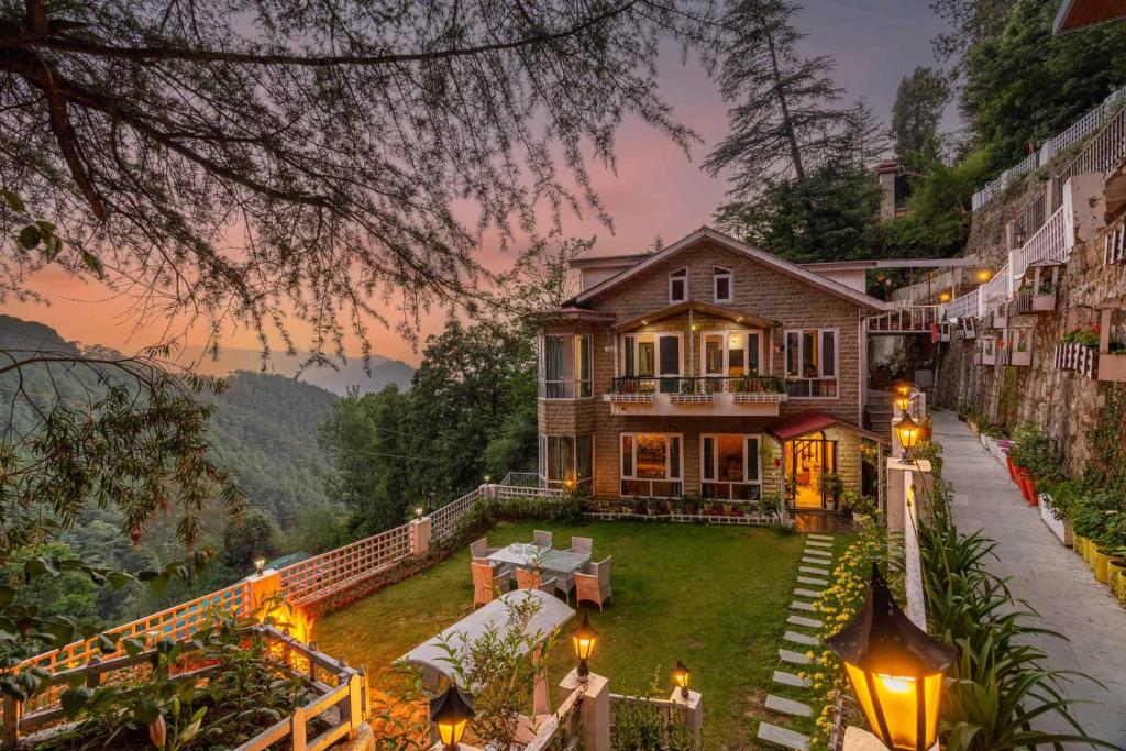 a large house with lights on the yard at Simla Manor by VEO - Part of StayVista in Shimla