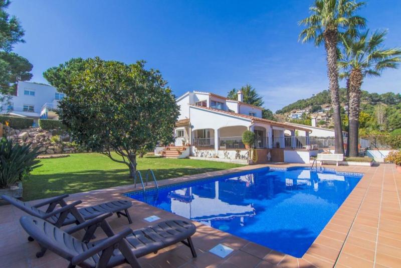a house with a swimming pool in front of a house at Club Villamar - Issei in Blanes