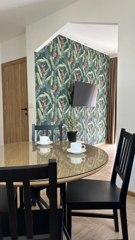 a dining room table with two chairs and a patterned wall at Apartmani Radmanovic in Tivat