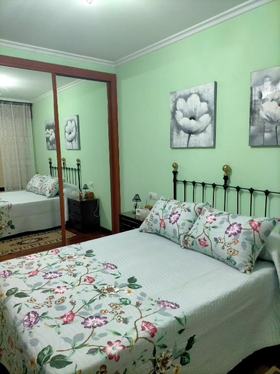 a bedroom with a bed and a mirror at El rinconcito de Aldán in Aldán