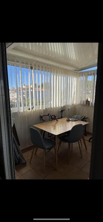 une salle à manger avec une table, des chaises et des fenêtres dans l'établissement Cosystcyp, à Saint-Cyprien