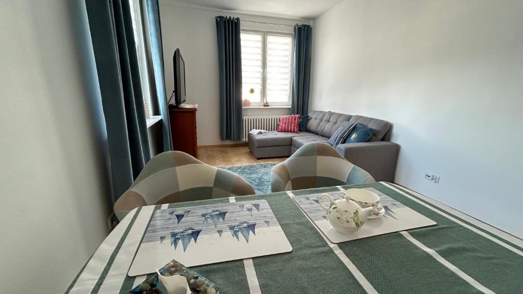 a living room with a table and a couch at Apartament Rodzinny Nad Morzem, Gdynia in Gdynia