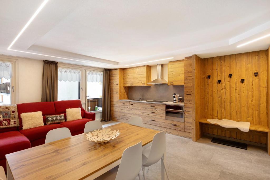 a living room with a red couch and a table at A Due Passi Rosso in Livigno