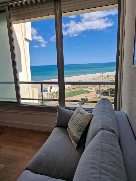 - un canapé dans le salon avec vue sur la plage dans l'établissement Virage au sud, au Barcarès