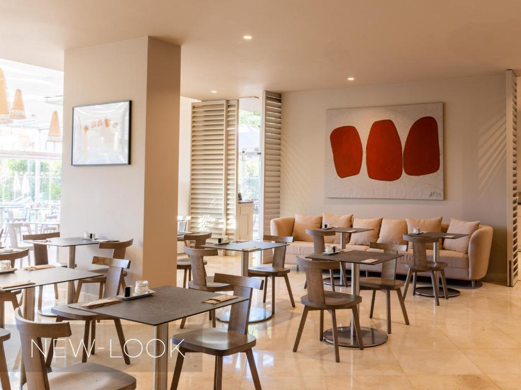 a restaurant with tables and chairs in a room at Aqua Pedra Dos Bicos Design Beach Hotel - Adults Friendly in Albufeira