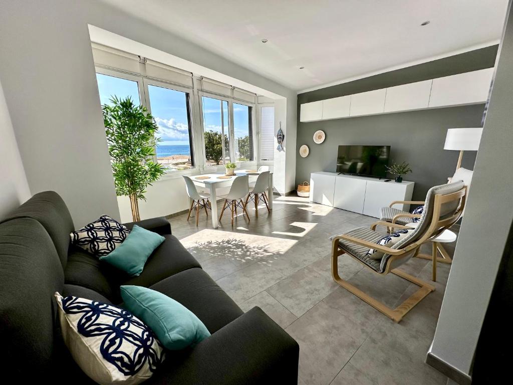 a living room with a couch and a table at Apartamento en primera linea con vistas al mar - VistaMar Blanes in Blanes