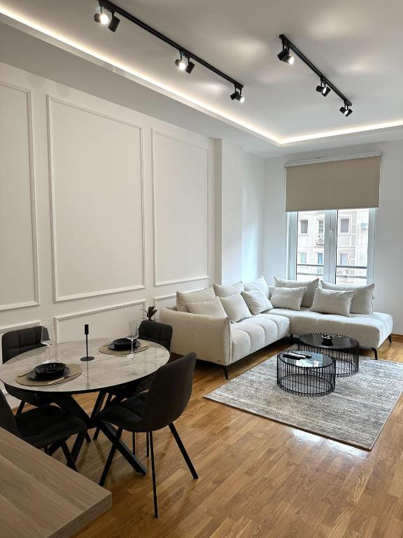 a living room with a white couch and a table at LU Apartment in Novi Sad