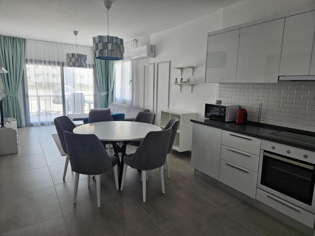 a kitchen and dining room with a table and chairs at Pompeius Beachside Retreat 2-Bedroom Apartment g-7 in Perivolia tou Trikomou