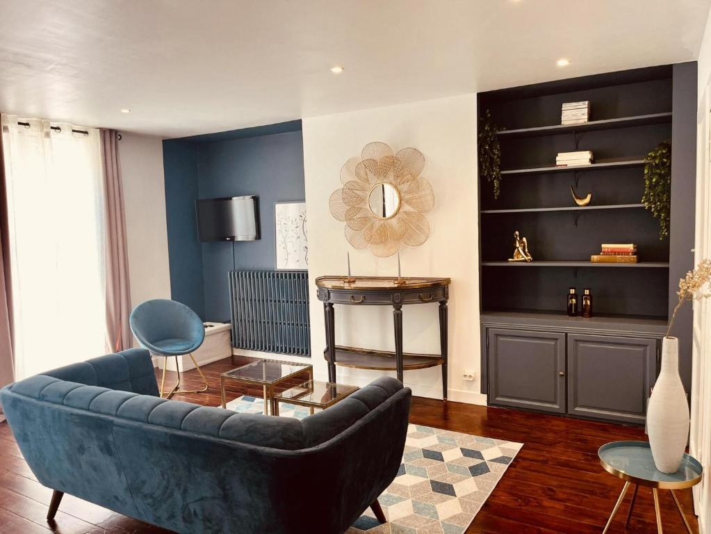 un salon avec un canapé bleu et une table dans l'établissement Escalier d'Or ConciergerieDameCarcas, à Carcassonne