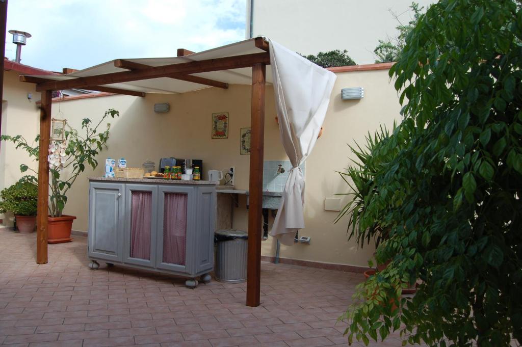 a patio with an outdoor kitchen with an umbrella at La Papaya in Marina di Pisa