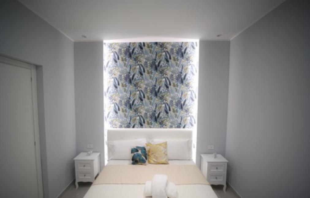 a bedroom with a bed with a large window at La casa di Penelope in Catania
