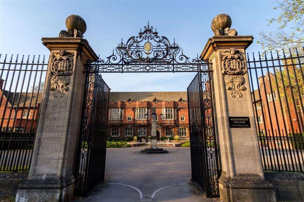 an ornate gate to a courtyard with a building at Westminster College in Cambridge